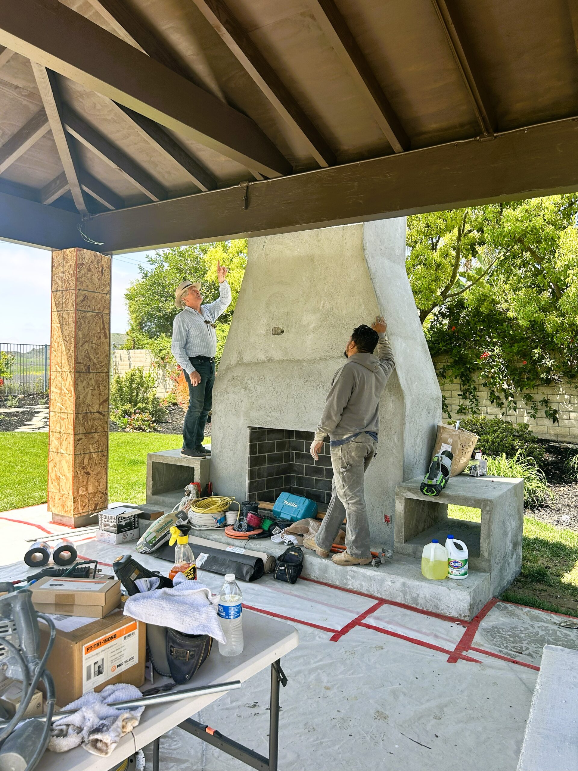 Two men reviewing the construction of a large masonry fireplace