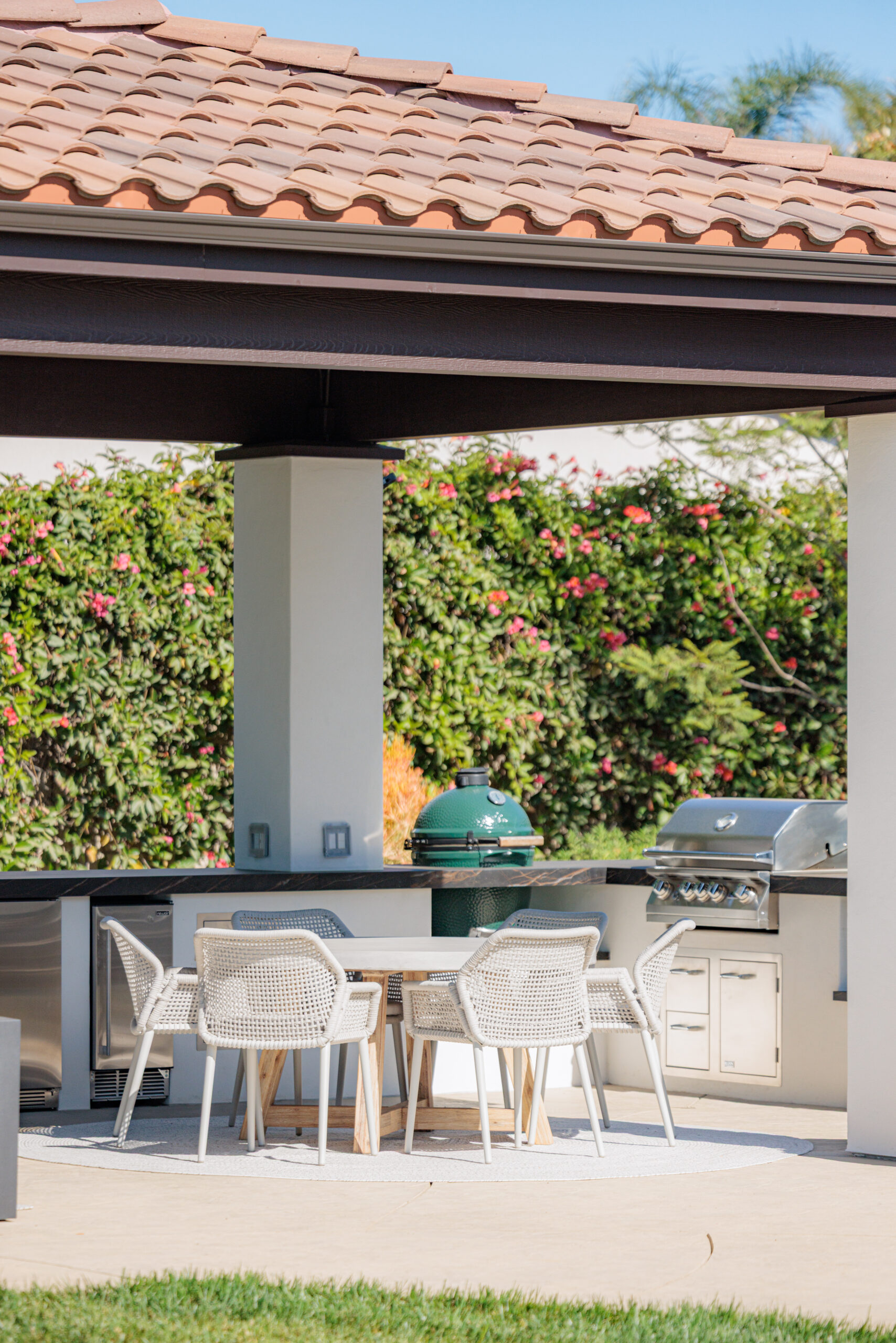 Custom outdoor kitchen with built-in grill, dining table, and covered patio for outdoor living and entertaining.