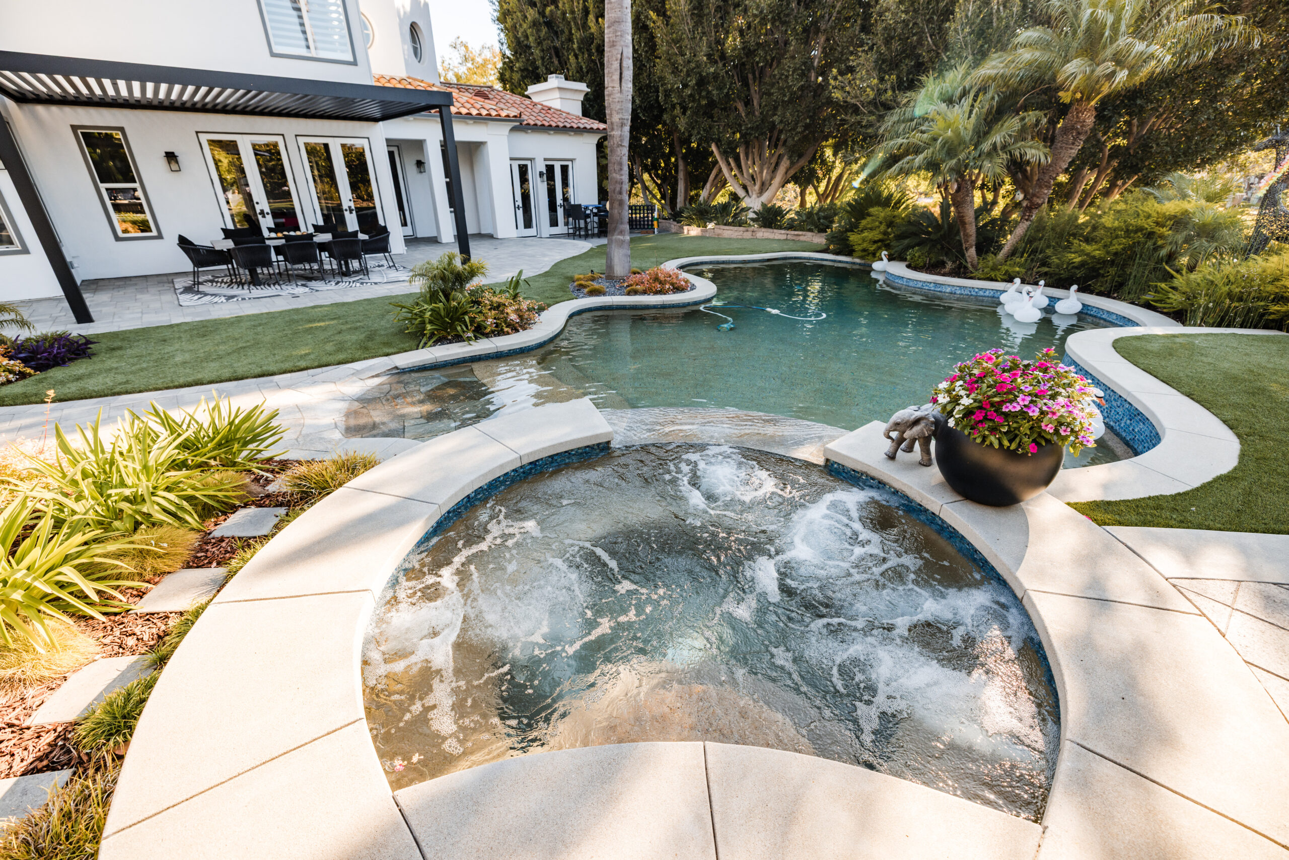 Freeform swimming pool and spa with lush landscaping and covered patio in Camarillo, California